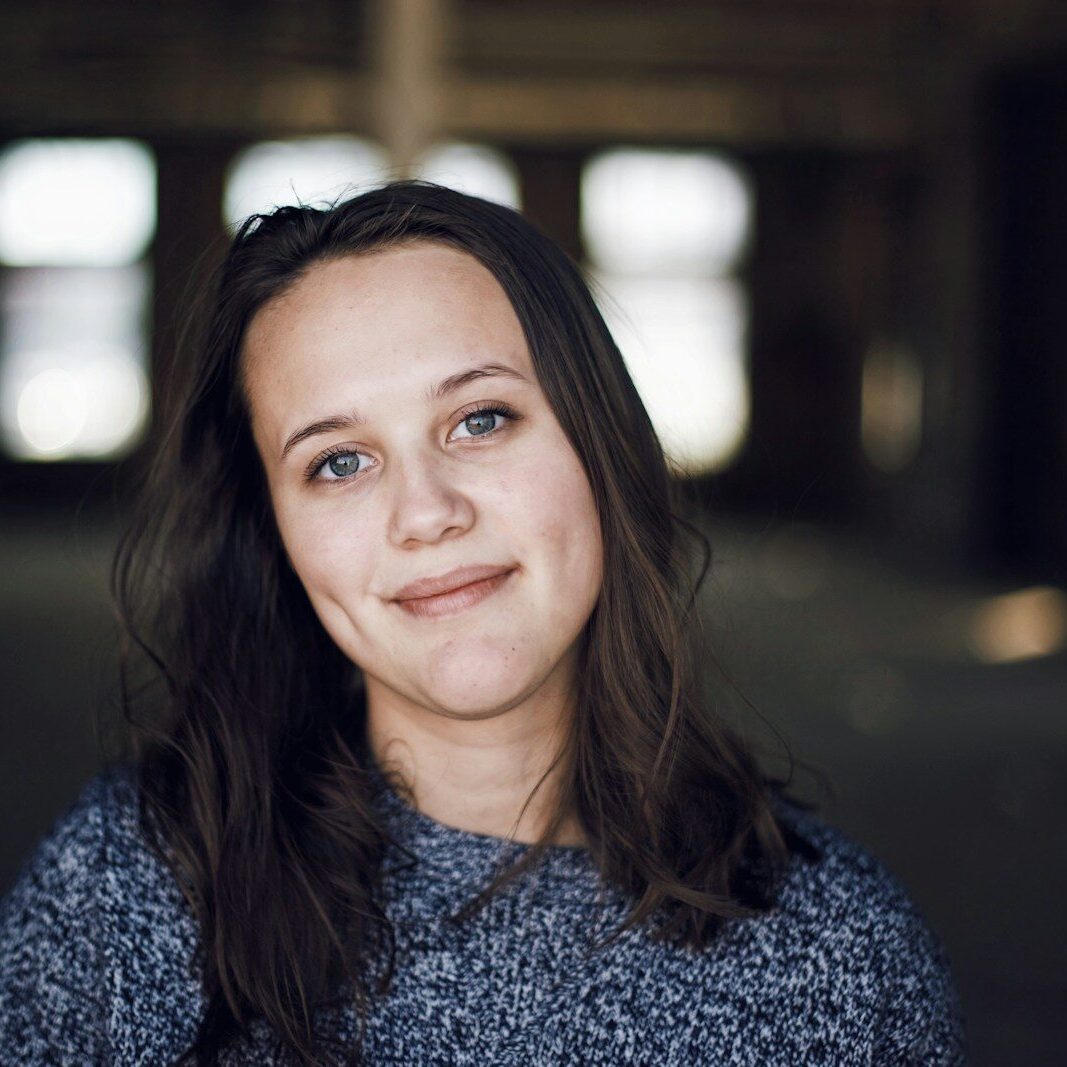a woman with long hair and blue eyes smiling