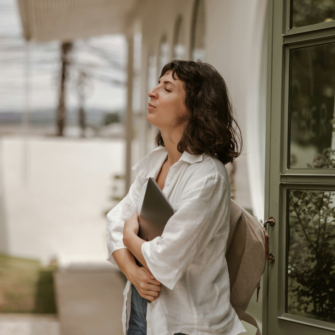 a woman standing outside of a building with a book in her hand