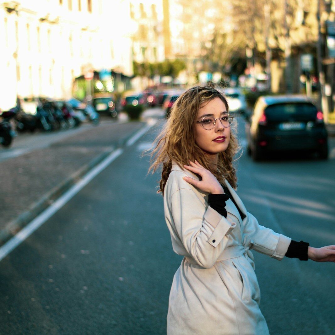 woman in white long sleeve shirt standing on road during daytime