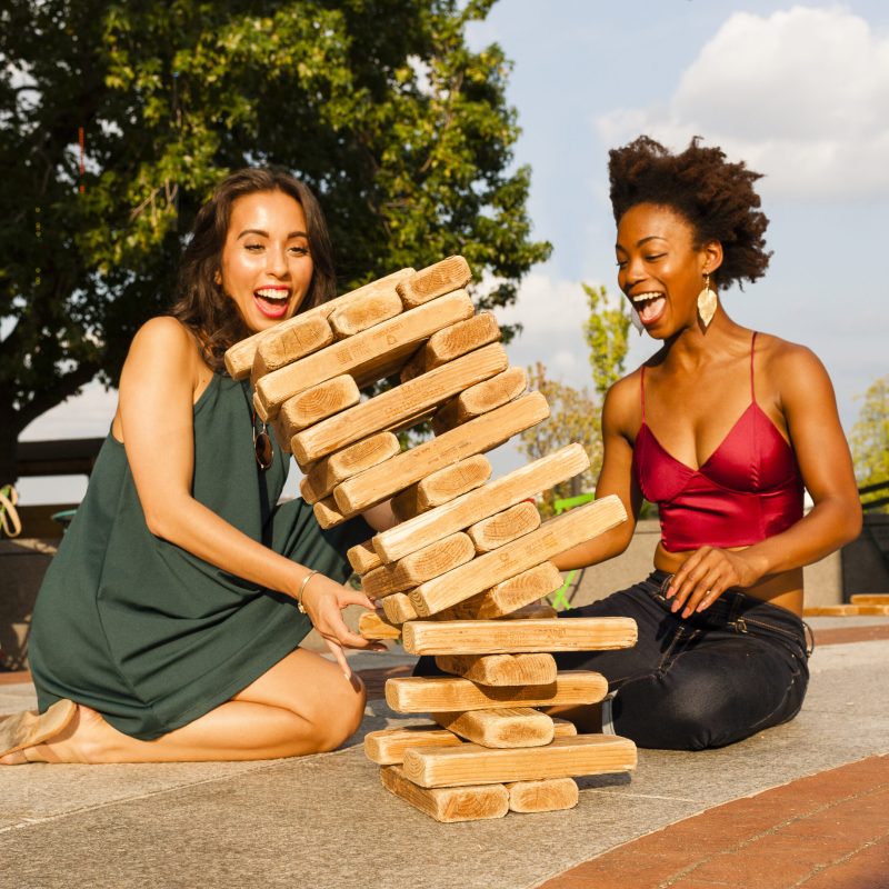 Young women playing with building blocks on floor